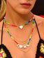Venessa Arizaga SS26 Rainbow Aura Necklace layered at collarbone with the Rainbow Heartbeat Adjustable Necklace worn as a choker, rainbow charms catching the light for sun-drenched Paradisiac escape and effortless surf-resort vibe.