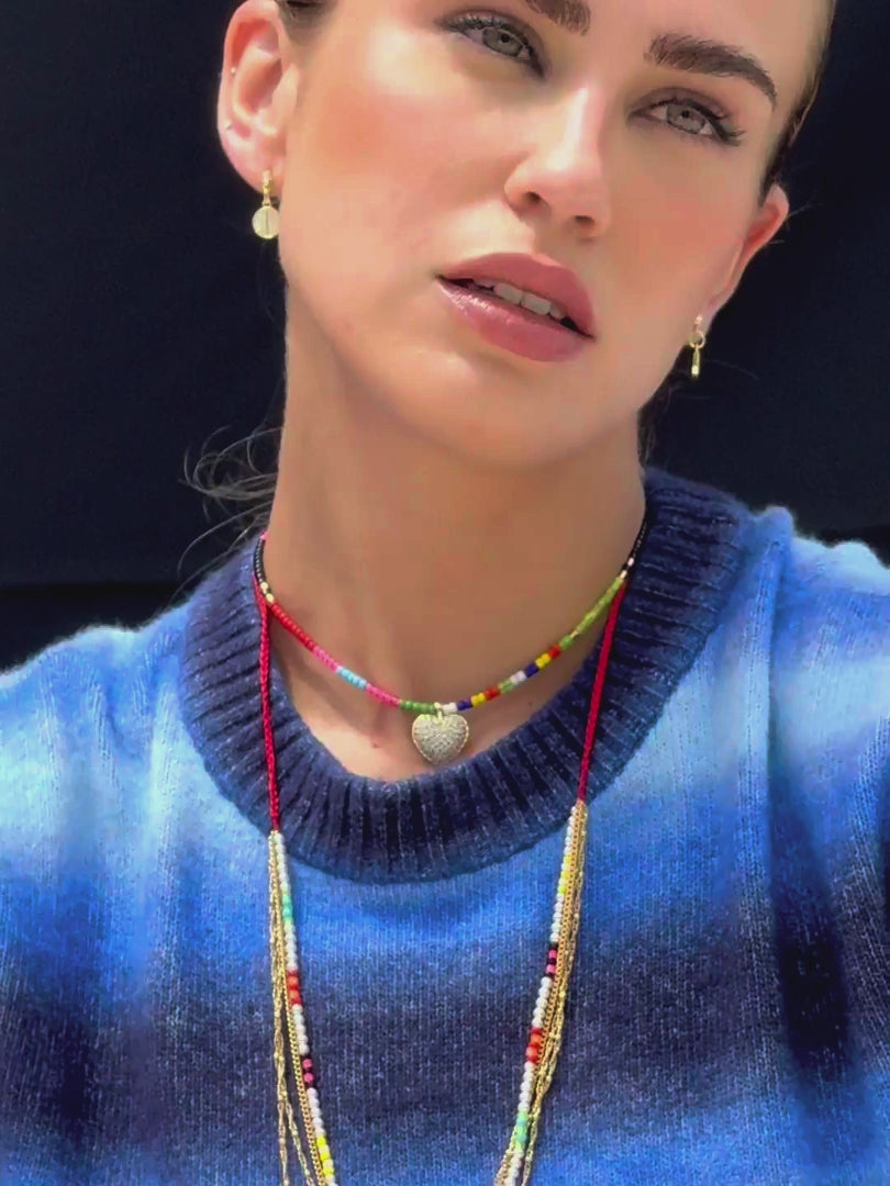 Close up video of model wearing Venessa Arizaga SS26 Color Crush Necklace layered with Love in Color adjustable Necklace worn as a choker, Peace Out Sparkle earrings, for everyday colorful wear